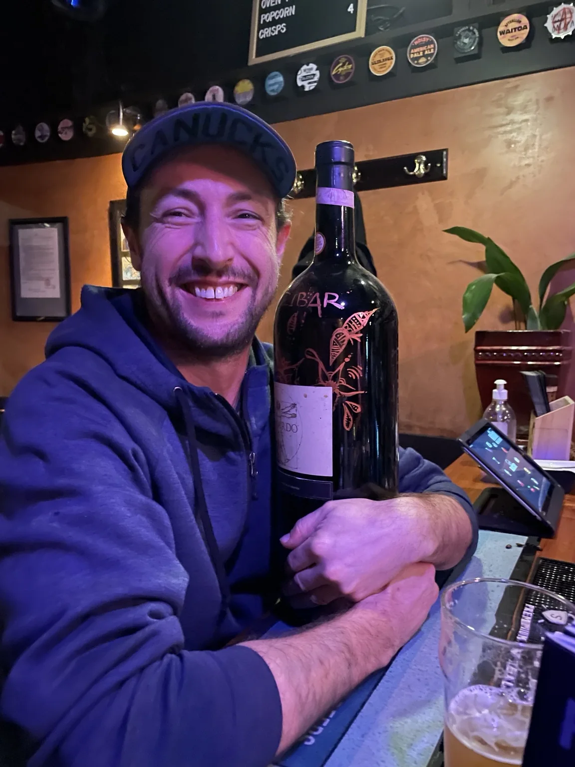 Ryan holding a large bottle of wine